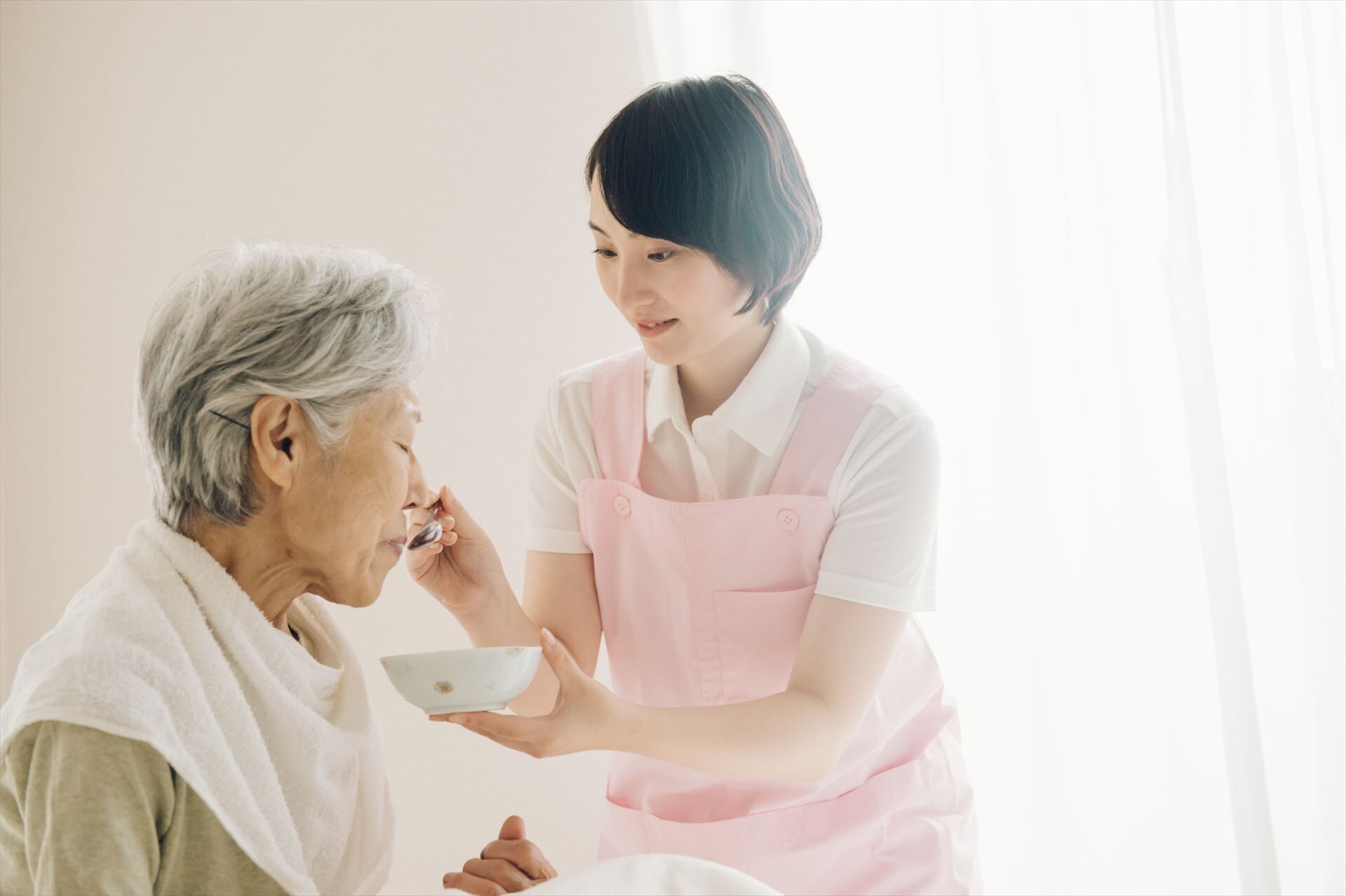 食事の介助をする女性ヘルパー